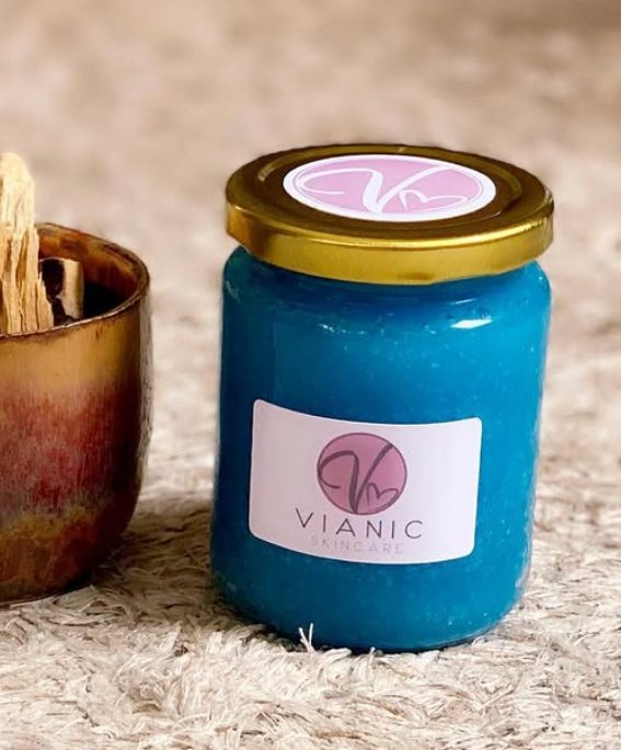 A Vianic sugar scrub jar beside palo santo